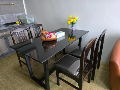 a black table with chairs and a vase of flowers on it at Victory Place in Bangkok