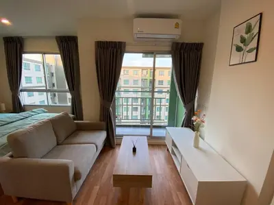 a living room with a couch and a large window at Garden Oasis Apartment: Condo Near Bangkok River in Ban Sai Ma