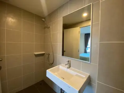a bathroom with a sink and a mirror at Garden Oasis Apartment: Condo Near Bangkok River in Ban Sai Ma