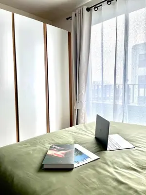 a laptop computer sitting on top of a bed at Elio Sukhumvit 64: Chic Space in Bangkok