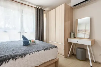 a bedroom with a bed and a mirror and a window at Elio Del Ray BTS Punnawithi in Bangkok
