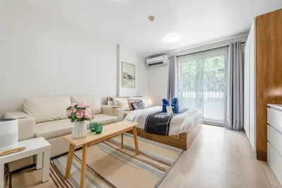 a living room with a couch and a bed at Elio Sukhumvit 64 in Bangkok