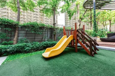 a playground with a slide in a garden at Elio Sukhumvit 64 in Bangkok
