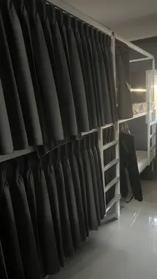 a wall of black curtains in a room at W District Guesthouse in Bangkok