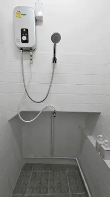 a shower in a bathroom with a hose at W District Guesthouse in Bangkok