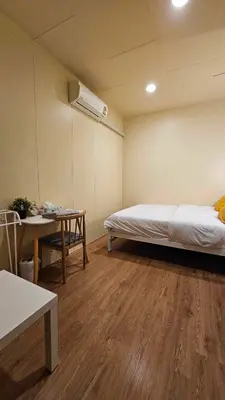 a room with a bed and a table and a bed sidx sidx sidx at W District Guesthouse in Bangkok