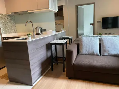 a kitchen with a couch next to a kitchen counter at Ceil by Sansiri BTS Ekamai Shuttle to BTS Ekamai , Gateway mall , Major Cineplex mid city. Great place to explore bangkok in Bangkok