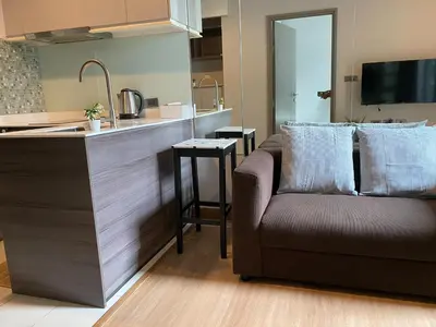 a living room with a couch and a kitchen at Ceil by Sansiri BTS Ekamai Shuttle to BTS Ekamai , Gateway mall , Major Cineplex mid city. Great place to explore bangkok in Bangkok