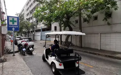 a golf cart parked on the side of a street at Sathon 15 apartment close to BTS Skytrain St Louis & Surasak in Bangkok