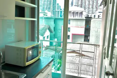 a television sitting on a counter in front of a window at Hip & Funky Sathon15 apartment close to BTS St Louis in Bangkok