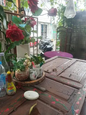 a wooden table with a flower arrangement on top of it at Caravan & Smart in Bangkok