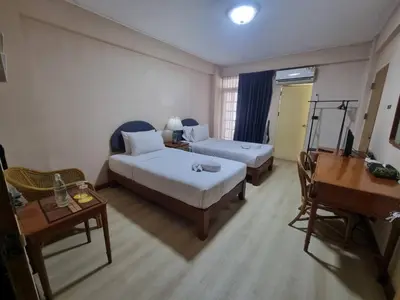 a bedroom with two beds and a desk and a piano at 12PM Bangkok in Bang Kapi