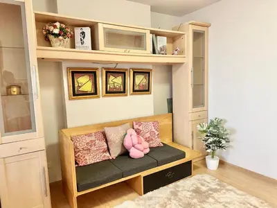 a room with a couch with pillows and a shelf at เช่ารายเดือน DCon Rattanathibet in Ban Sai Ma
