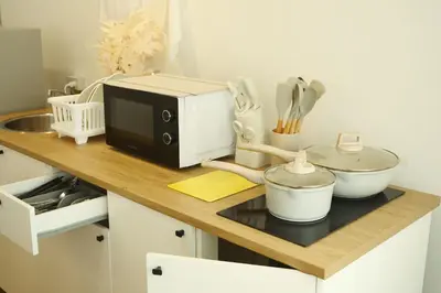 a kitchen counter with a microwave and some utensils at 2BR Stylist Rare Find China Town in Bangkok