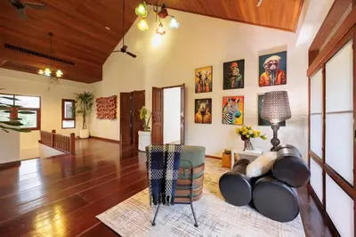a living room with a couch and paintings on the wall at \u66fc\u8c372000\u5e73\u65b9\u7c73\u5e84\u56ed\u522b\u5885 \u8d85\u5927\u6cf3\u6c60sukhmvit\u4f4d\u7f6e\u7edd\u4f73 9\u95f4\u5367\u5ba4 in Amphoe Phra Khanong