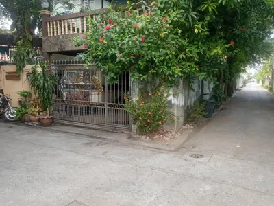 a fence with flowers on it next to a street at Best Place Have Air Conditioner in Bangkok