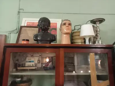 a wooden cabinet with a shelf with items on it at Bang lumphu house&bistro in Bangkok