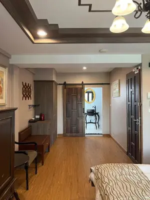 a bedroom with a bed and a desk and a table at Quinstel Guesthouse in Bangkok