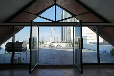 an open glass door with a view of the city at Rooftop Paradise & Koi Pond-6BR Hideaway@Icon Siam in Bangkok