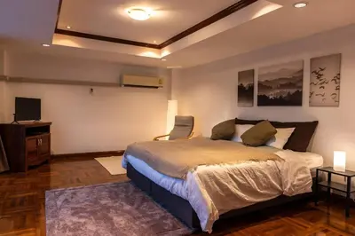 a bedroom with a bed and a desk and a television at Rooftop Paradise & Koi Pond-6BR Hideaway@Icon Siam in Bangkok