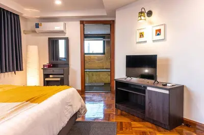 a bedroom with a bed and a flat screen tv at Rooftop Paradise & Koi Pond-6BR Hideaway@Icon Siam in Bangkok