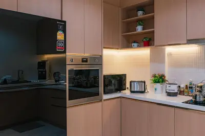 a kitchen with wooden cabinets and a stove top oven at PRIME SUKHUMVIT MODERN HOME, Phrom Phong BTS, Em District, Up to 14 guests in Bangkok