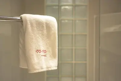 a towel hanging on a towel rack in a bathroom at Coco Hotel in Bangkok