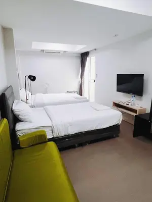 a hotel room with two beds and a flat screen tv at Mitr Inn Mrt Samyot Station - The Grand Palace in Bangkok