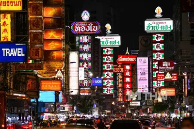 a busy city street at night with neon signs at Mitr Inn Mrt Samyot Station - The Grand Palace in Bangkok