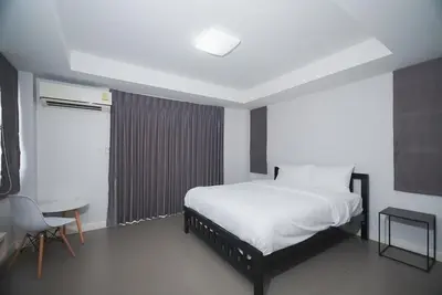 a bedroom with a bed and a table and a chair at Mitr Inn Mrt Samyot Station - The Grand Palace in Bangkok