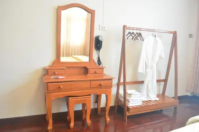 a wooden dresser with a mirror and a phone at Sweety Secret Guesthouse in Ban Tambon Bang Khae