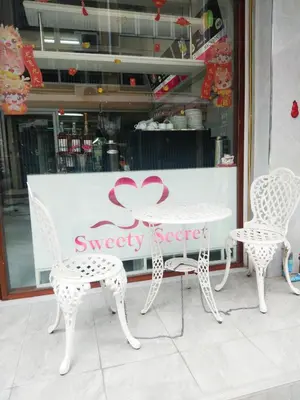 a white table and chairs in front of a store at Sweety Secret Guesthouse in Ban Tambon Bang Khae