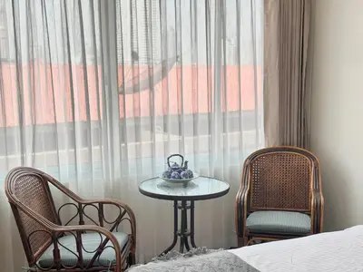 a room with a table and two chairs and a window at Longzhu Guesthouse in Bangkok