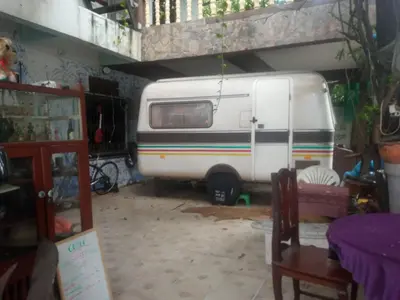 a white van is parked in a garage at Caravan Hotel have TV & Netflix in Bangkok