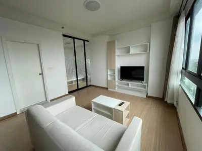 a living room with a white couch and a tv at 1BR Apartment in Bangkok