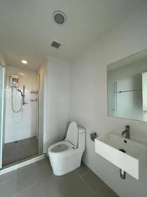 a bathroom with a toilet and a sink and a shower at 1BR Apartment in Bangkok