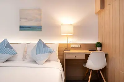 a bedroom with a bed with a desk and a chair at สินสิริ นวมินทร์96 in Ban Baen Phichit