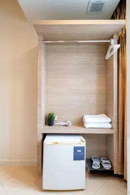a small refrigerator in a room with a shelf at สินสิริ นวมินทร์96 in Ban Baen Phichit