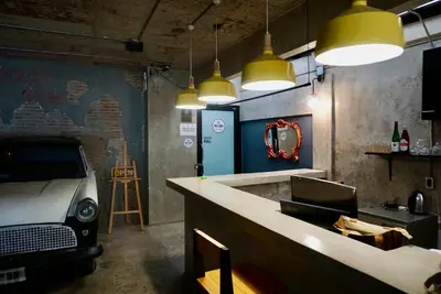 a bar with a car parked in a room with lights at Hip and funky apartment silom Soi 3, with rooftop view in Bangkok