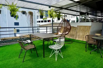 a patio with a table and chairs on grass at Hip and funky apartment silom Soi 3, with rooftop view in Bangkok
