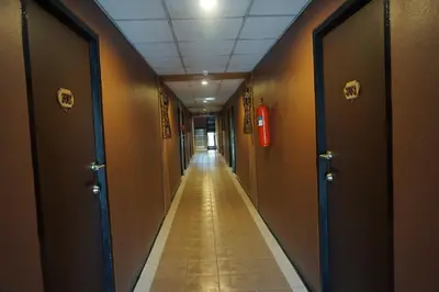 an empty hallway with doors and a long corridor at Bangkok Travel Suites Hotel in Nonthaburi