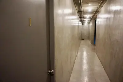 a long hallway with a door and a long corridor at Silom Soi 3 Hash Apartment hip and funky with rooftop view in Bangkok