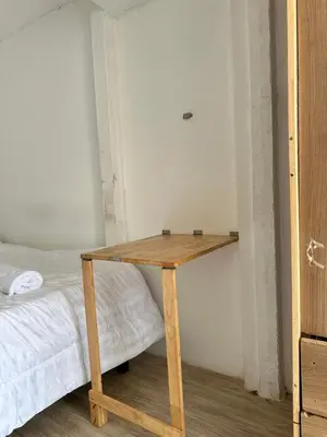 a wooden table in a room next to a bed at Chubby 9 single room in Bangkok