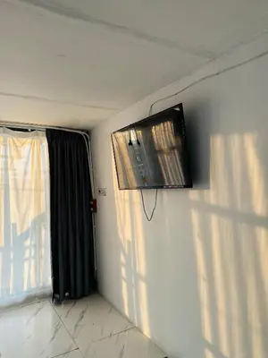 a room with a tv on the wall next to a window at Chubby 9 in Bang O