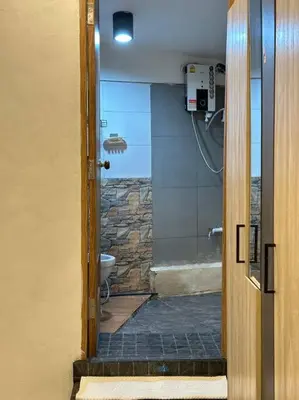 a bathroom with a shower and a toilet with a glass door at Chubby 5 Room 5 in Bangkok