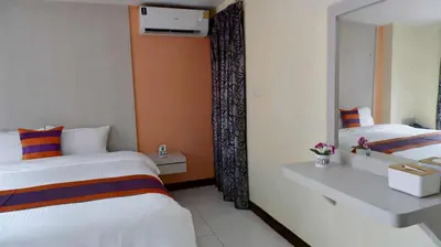 a hotel room with a bed and a mirror at Aryan Suites Hotel in Bangkok