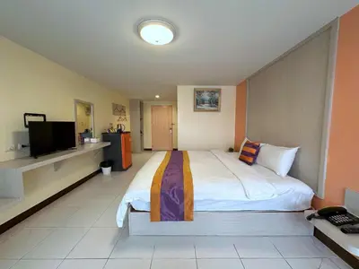 a bedroom with a large bed and a flat screen tv at Aryan Suites Hotel in Bangkok