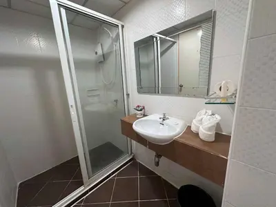 a bathroom with a sink and a shower at Aryan Suites Hotel in Bangkok