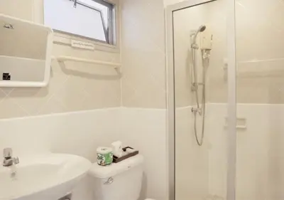 a bathroom with a shower and a toilet and a sink at Kiatthada Resort in Bangkok