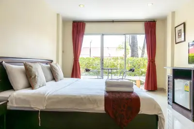 a bedroom with a large bed and a window at Kiatthada Resort in Bangkok